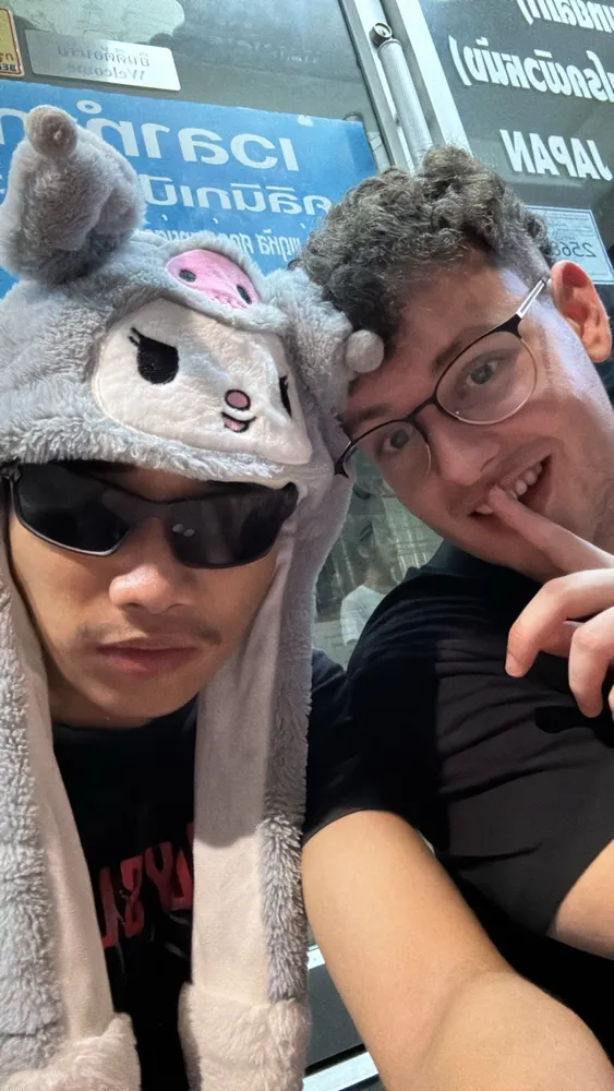 Two friends taking a selfie, one wearing an animal hat