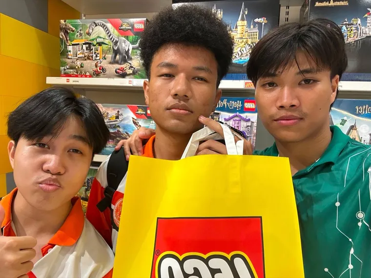 Three friends posing with a yellow shopping bag
