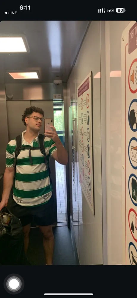 A friend in a green striped football shirt in a doorway