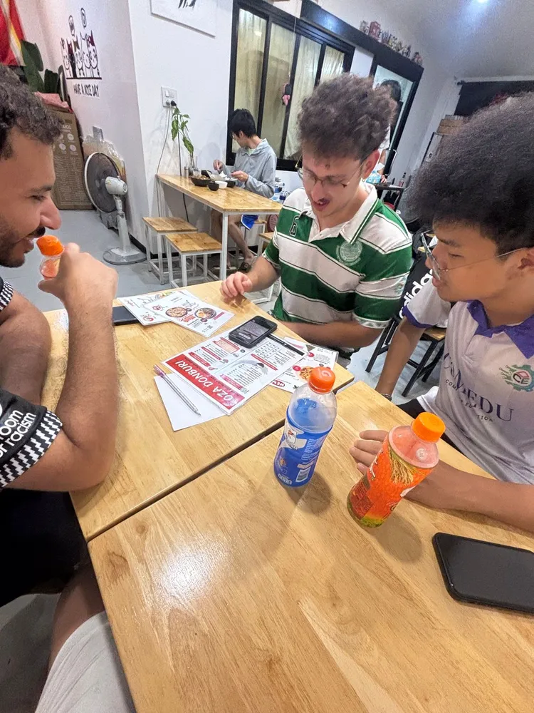 Friends around a restaurant table in football shirts